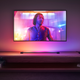 A photo of the light tube shining a purple-yellow gradient underneath a TV